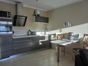 eine Küche mit Küchengeräten aus Edelstahl und einem Tisch in der Unterkunft Ferienwohnung LP8 "Deck Zwei" in Graal-Müritz