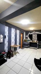a living room with a table and a kitchen at Cabanatuan City PNY Transient INN 2 in Cabanatuan