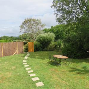 un jardin avec une table et un chemin dans la pelouse dans l'établissement LE PETIT NID DANS LA ROULOTTE, à Roscanvel