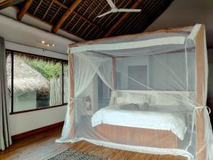 a bedroom with a canopy bed in a room at The Beach House in Inhambane