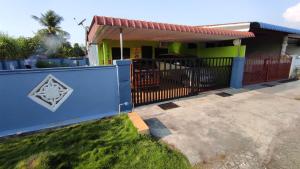 Homestay Opah Parit Buntar, Perak في باريت بونتار: منزل به سياج ازرق وبوابه