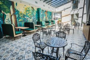 a restaurant with tables and chairs and a mural at Garden Suites Pinamar in Pinamar