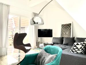 una sala de estar con un sofá y una mesa en Das Stader Loft mit Sonnenbalkon, en Stade