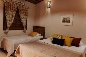 En eller flere senge i et værelse på Hotel Pousada Chalé das Flores