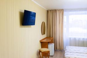 a bedroom with a bed and a tv on the wall at Отель Турист in Ivanovo