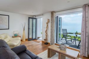 a living room with a couch and a view of the ocean at Beach Retreat - Mount Brioni in Downderry