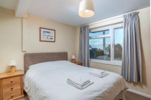 a bedroom with a white bed and a window at Apartment 2 - Mount Brioni in Downderry