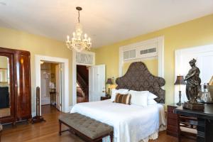 a bedroom with a large bed and a chandelier at Kehoe House, Historic Inns of Savannah Collection in Savannah
