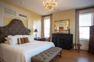 a bedroom with a large bed and a chandelier at Kehoe House, Historic Inns of Savannah Collection in Savannah