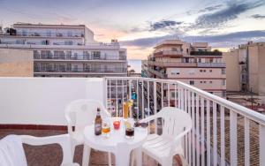 een tafel en stoelen op een balkon met drankjes bij SB Arenal in El Arenal