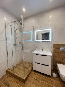 ein Bad mit einer Dusche und einem Waschbecken in der Unterkunft Апартаменты SUOMI в жк Империал in Truskawez