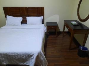 1 dormitorio con cama blanca, escritorio y espejo en شقق درر رامه للشقق المخدومة 12 en Riad