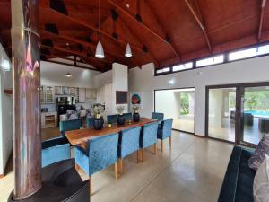 a dining room with a long table and blue chairs at No 16 Elements - 5 Bedroom Beauty in Moheme