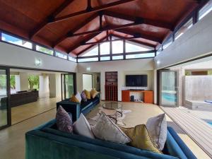 a large living room with a blue couch and a table at No 16 Elements - 5 Bedroom Beauty in Moheme