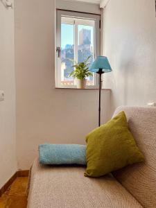 Habitación con sofá, almohada y ventana en CASA CRIS OLDTOWN Cazorla, en Cazorla