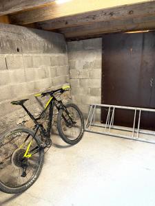 una bicicleta estacionada al lado de un edificio con una puerta en Le CHAL HEUREUX bel appartement dans vieille ferme de montagne rénovée en Les Orres