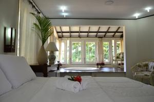 a bedroom with a bed and a tub in a room at Aimberê Eco Resort Hotel in Coqueiro