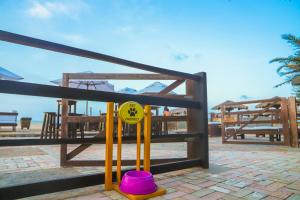 a playground with a yellow and purple bucket in front of a fence at Aimberê Eco Resort Hotel in Coqueiro