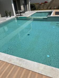 a swimming pool with blue water in a building at Twins Apartments in Plataniás