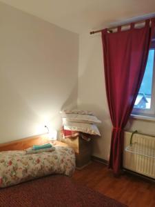 a bedroom with a bed and a red curtain at Apartment Valea Azugii in Azuga