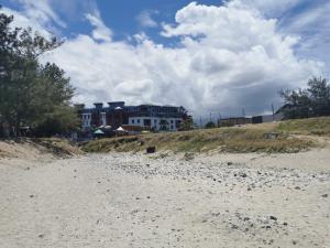 a sandy beach with a house in the background at Superbe studio en bord de mer in Saint-Pierre