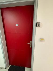 une porte rouge avec un panneau dans une pièce dans l'établissement Superbe studio en bord de mer, à Saint-Pierre