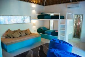 Zimmer mit 2 Etagenbetten und einem Sofa in der Unterkunft Rapture Surfcamps Green Bowl in Ungasan + 37 Fotos
