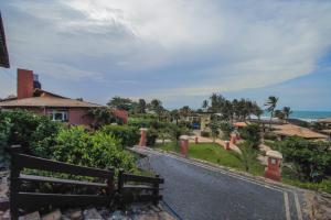 a road leading to a house and the ocean at Aimberê Eco Resort Hotel in Coqueiro
