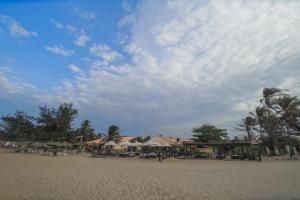 a beach with chairs and umbrellas on the sand at Aimberê Eco Resort Hotel in Coqueiro