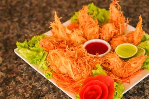 a white plate of food with lettuce and shrimp at Aimberê Eco Resort Hotel in Coqueiro