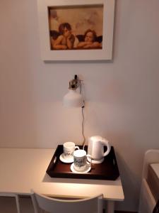 - une table avec deux tasses à café et une lampe dans l'établissement CASA PASTEUR a due passi da Ostuni, à Carovigno