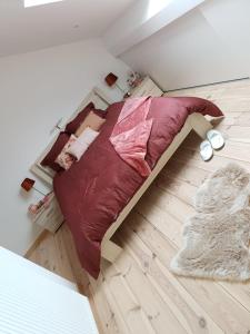 a bed sitting on a wooden floor in a bedroom at La Mara Élo in Sart-lez-Spa