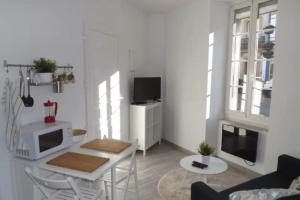 a white living room with a table and a tv at DUPLEX DU GET in Revel