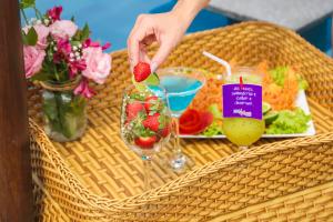 a person holding a strawberry in a wine glass at Aimberê Eco Resort Hotel in Coqueiro