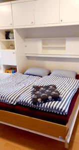 a bed with blue and white striped sheets at Piratennest Nord in Bordelum