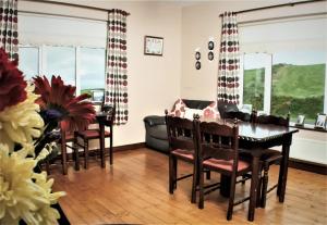 a dining room with a table and chairs and a couch at Hilltop B & B in Kilkee