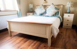 um quarto com uma grande cama branca com almofadas azuis em Hilltop B & B em Kilkee