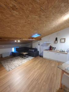 ein Wohnzimmer mit einem blauen Sofa und einer Küche in der Unterkunft LOFT DU GET in Revel