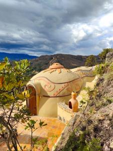 a building with a dome on top of a hill at Paraiso de Arcilla - Suite & Glamping in Ráquira