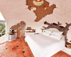 a bedroom with a bed with a tree branch on the wall at Paraiso de Arcilla - Suite & Glamping in Ráquira