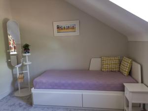 a small bedroom with a bed with a purple mattress at Bournemouth cottage 6mins from beach, free parking in Bournemouth