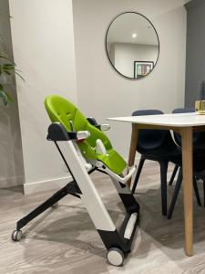 a green chair next to a table and a mirror at Bournemouth cottage 6mins from beach, free parking in Bournemouth