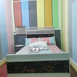 a bed in a room with colorful walls at Cabanatuan City PNY TRANSIENT INN 3 in Cabanatuan