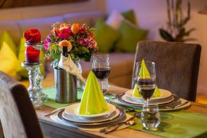 una mesa con platos y copas de vino y flores en Ferienwohnung Hörndlwand Ruhpolding en Ruhpolding