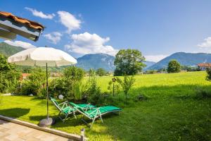 a couple of chairs and an umbrella in the grass at Ferienwohnung Hörndlwand Ruhpolding in Ruhpolding
