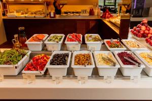 Gradiali Wellness and SPA في بالانغا: خزانة عرض مع مجموعة من أنواع الطعام المختلفة