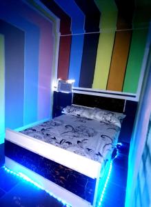 Habitación con cama con paredes y luces de colores. en Cabanatuan City PNY TRANSIENT INN 3 en Cabanatuan