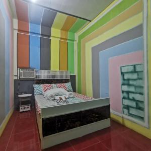 a bedroom with a bed with a colorful wall at Cabanatuan City PNY TRANSIENT INN 3 in Cabanatuan