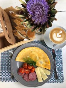 a table with a plate of food and a cup of coffee at Boho House in Pakoštane