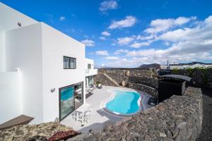 Casa blanca con pared de piedra y piscina en Villa Tinguaton en Tinguatón